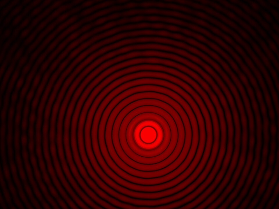 An Airy diffraction pattern: a bright red central spot ringed by concentric side lobes